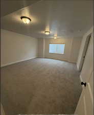 Carpeted spare room with a textured ceiling