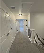 Corridor featuring carpet floors and a textured ceiling