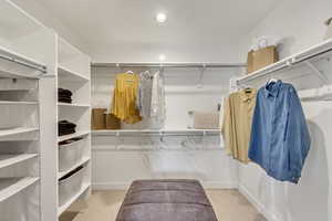 Walk in closet featuring light colored carpet