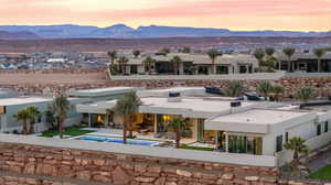 Back house at dusk with a mountain view and a patio