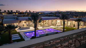 Back house at dusk with a patio area