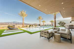 View of patio featuring an outdoor living space, a mountain view, and a fenced in pool