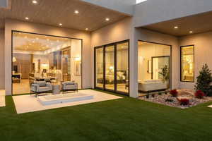 Rear view of house with an outdoor hangout area, a patio, and a lawn