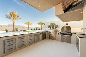 View of patio featuring a mountain view, sink, an outdoor kitchen, and area for grilling