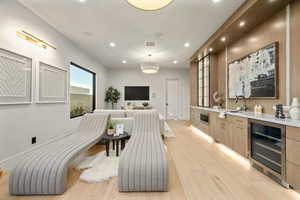 Interior space featuring wet bar, beverage cooler, and light hardwood / wood-style floors