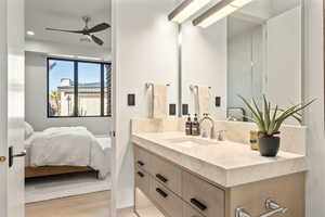 Bathroom with wood-type flooring, ceiling fan, and vanity