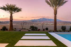 Yard at dusk featuring a fenced in pool and a water and mountain view