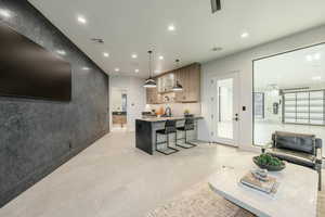 Interior space featuring a kitchen bar, pendant lighting, sink, and a kitchen island