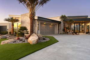 Contemporary house featuring a garage and a lawn