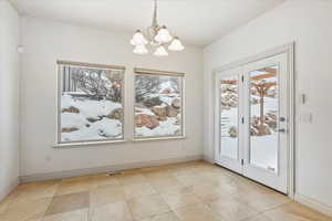 Unfurnished dining area with light tile patterned flooring and a chandelier