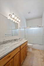 Full bathroom with enclosed tub / shower combo, vanity, tile patterned flooring, and toilet