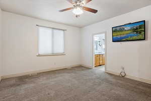 Carpeted empty room featuring ceiling fan