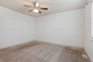 Carpeted spare room with ceiling fan