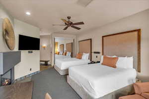 Carpeted bedroom with ceiling fan and a closet