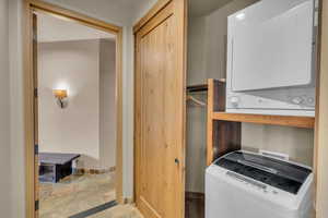 Washroom featuring stacked washing maching and dryer