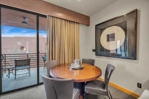 Carpeted dining space with ceiling fan