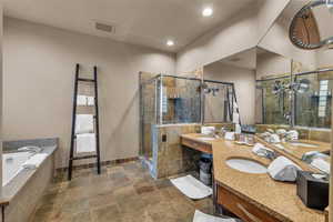 Bathroom featuring vanity and independent shower and bath