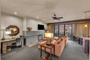 Carpeted living room featuring ceiling fan