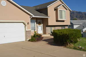 View of front facade with a garage and a mountain view