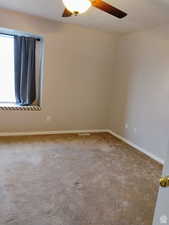 Spare room with ceiling fan and carpet floors