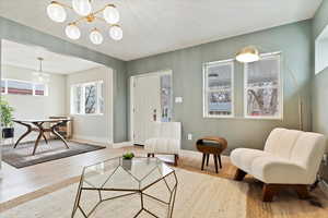 Living room with hardwood / wood-style flooring and an inviting chandelier