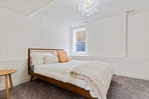 Carpeted bedroom featuring a chandelier