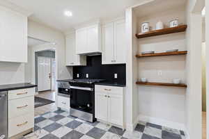 Kitchen with white cabinetry, backsplash, and appliances with stainless steel finishes