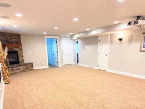 Basement media/family room with carpet and a fireplace