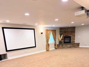 Carpeted home theater with a fireplace