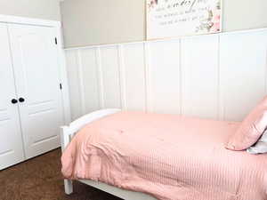 Carpeted bedroom with a closet, ceiling fan, and vaulted ceiling