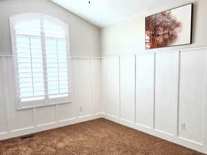 Spare room with ceiling fan, carpet, a textured ceiling, and lofted ceiling