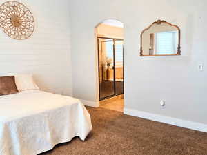 Bedroom featuring ceiling fan, carpet flooring, and ensuite bath