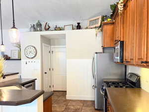 Kitchen with hanging light fixtures, sink, stainless steel appliances, and tasteful backsplash