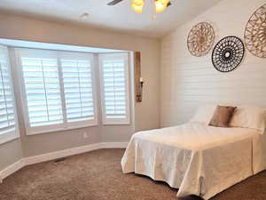 Master Bedroom featuring vaulted ceiling, shiplap, carpet floors, and ceiling fan