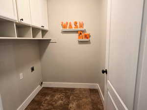 Laundry room with a textured ceiling, cabinets, and hookup for an electric dryer