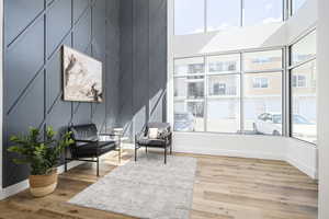 Interior space with light wood-type flooring, a towering ceiling, and a wealth of natural light