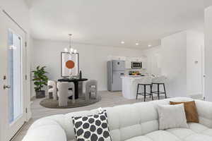 Living room with light wood-type flooring and a chandelier