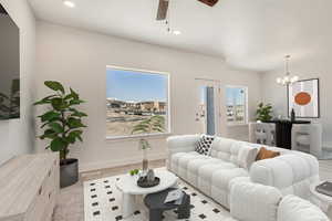 Living room featuring ceiling fan with notable chandelier