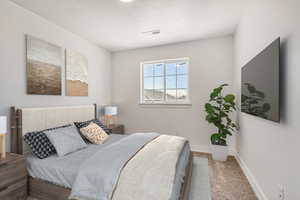 Carpeted bedroom featuring a textured ceiling