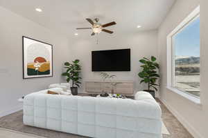 Carpeted living room featuring ceiling fan