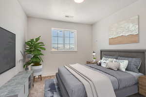 Bedroom with a textured ceiling and light colored carpet