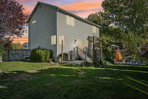 Back house at dusk featuring a yard