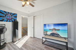 Bedroom featuring a closet, hardwood / wood-style floors, and ceiling fan