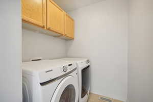 Washroom with cabinets and independent washer and dryer