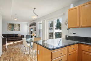 Kitchen featuring light wood-type flooring and dark stone counters