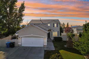 Front of property featuring a garage and a lawn