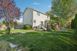 Back of property with a playground and a yard