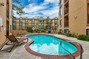 View of pool featuring a patio and area for grilling