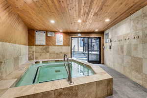 View of swimming pool with an indoor in ground hot tub