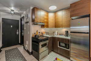 Kitchen featuring stainless steel appliances, backsplash, a textured ceiling, and sink